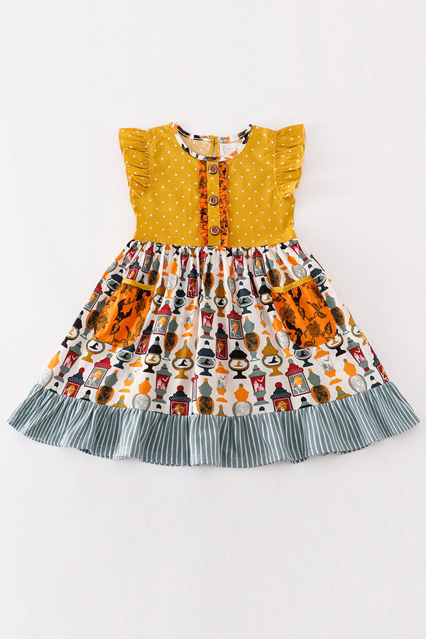 Children's dress with a yellow top and patterned skirt on a white background