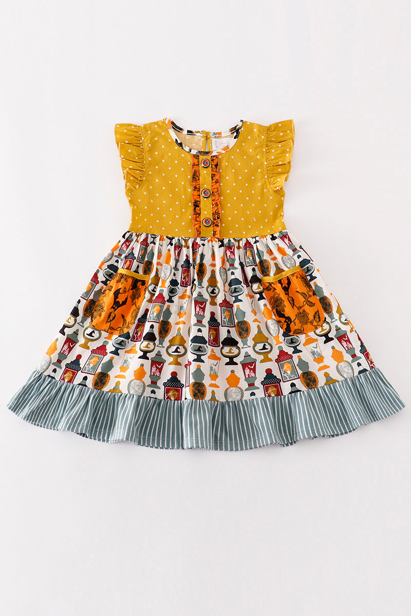Children's dress with a yellow top and patterned skirt on a white background