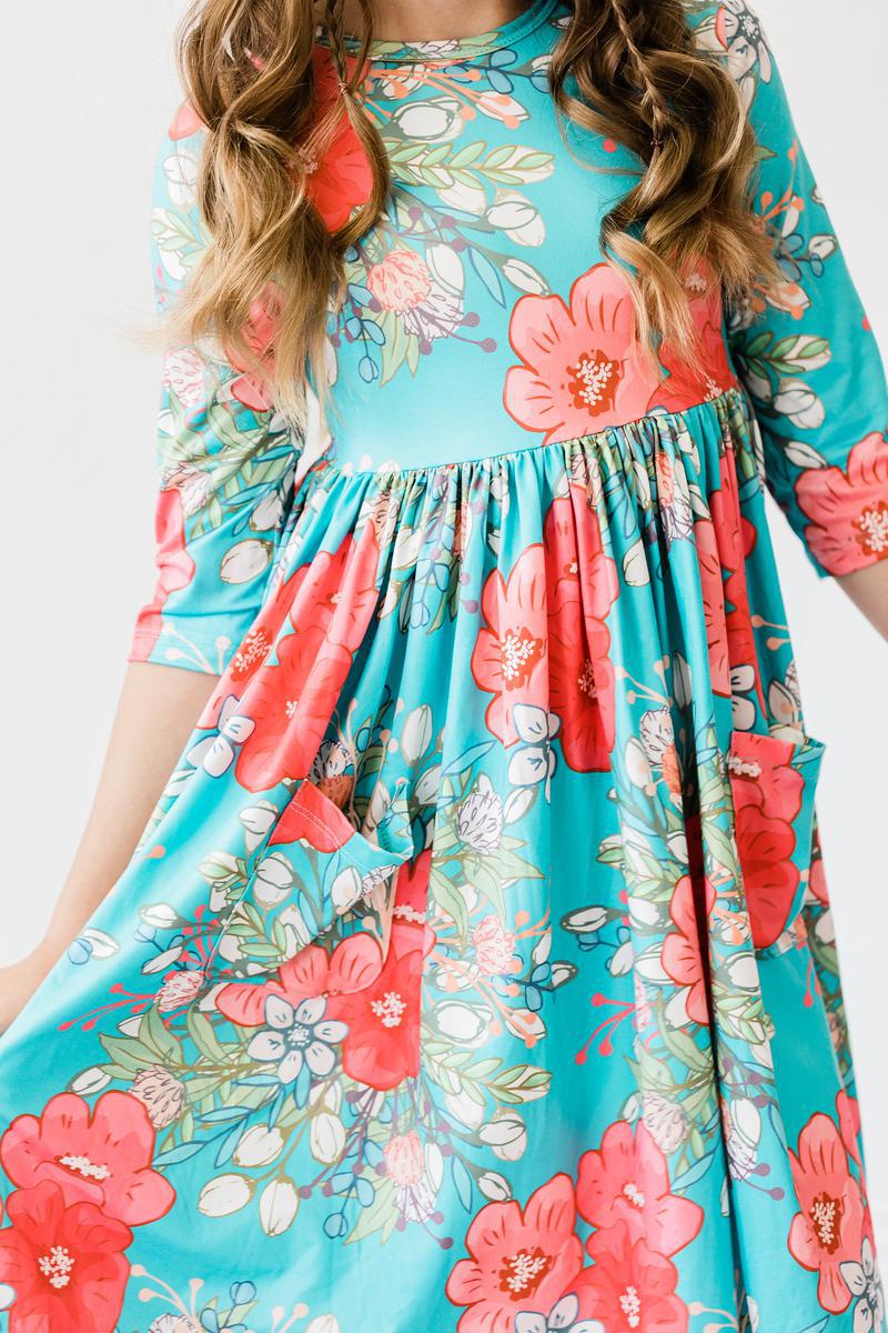 After the Rain 3/4 Sleeve Pocket Twirl Dress showcasing vibrant floral patterns, designed as a twirl dress for girls, perfect for school and special occasions.