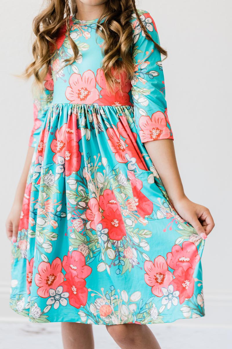 A girl joyfully posing in the After the Rain 3/4 Sleeve Pocket Twirl Dress, a stylish and fun twirl dress for girls, perfect for twirling and play.