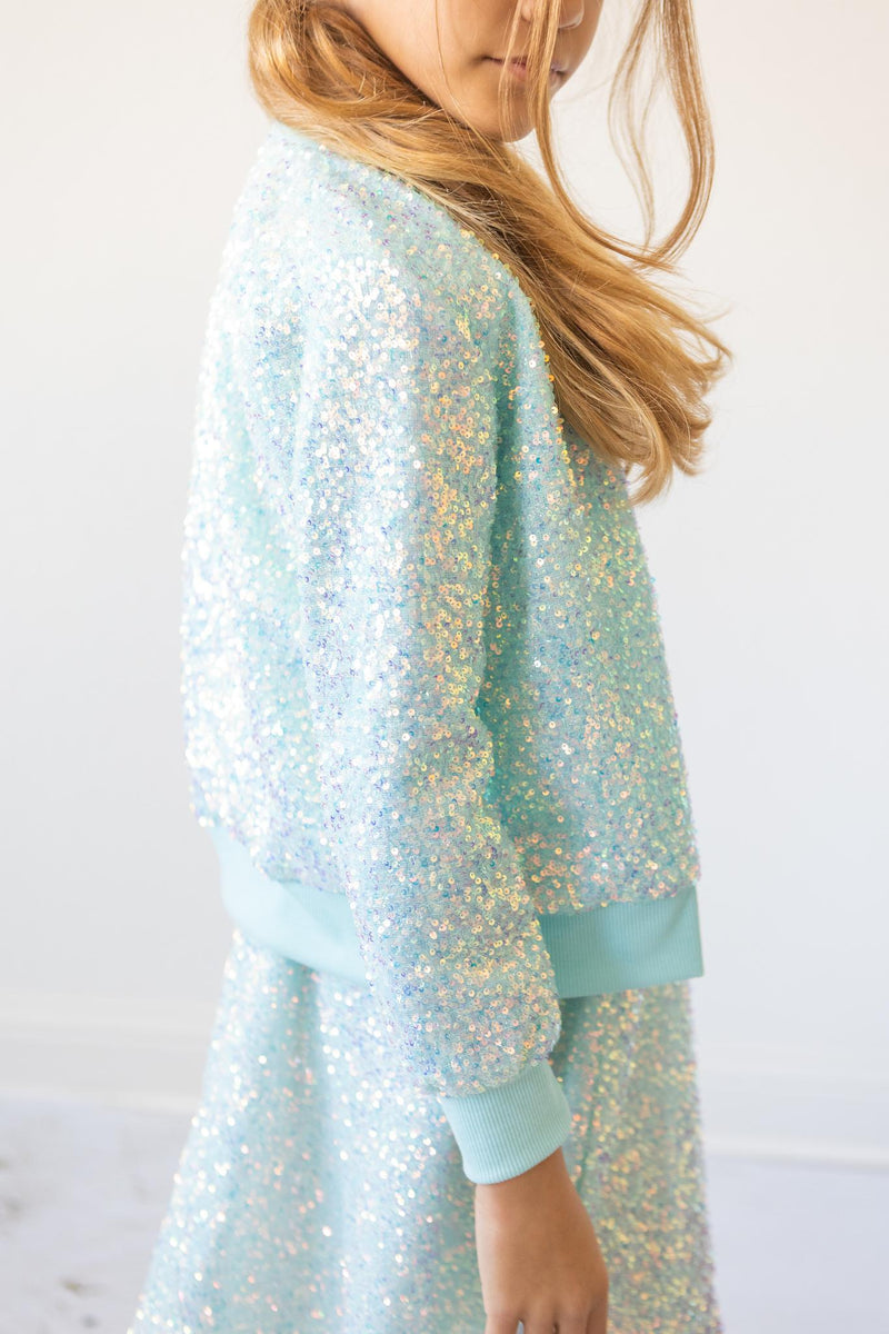 Aqua Sequin Jacket for Girls showcased as a stylish outfit, featuring shimmering sequins and a cozy fit, perfect for little fashionistas.