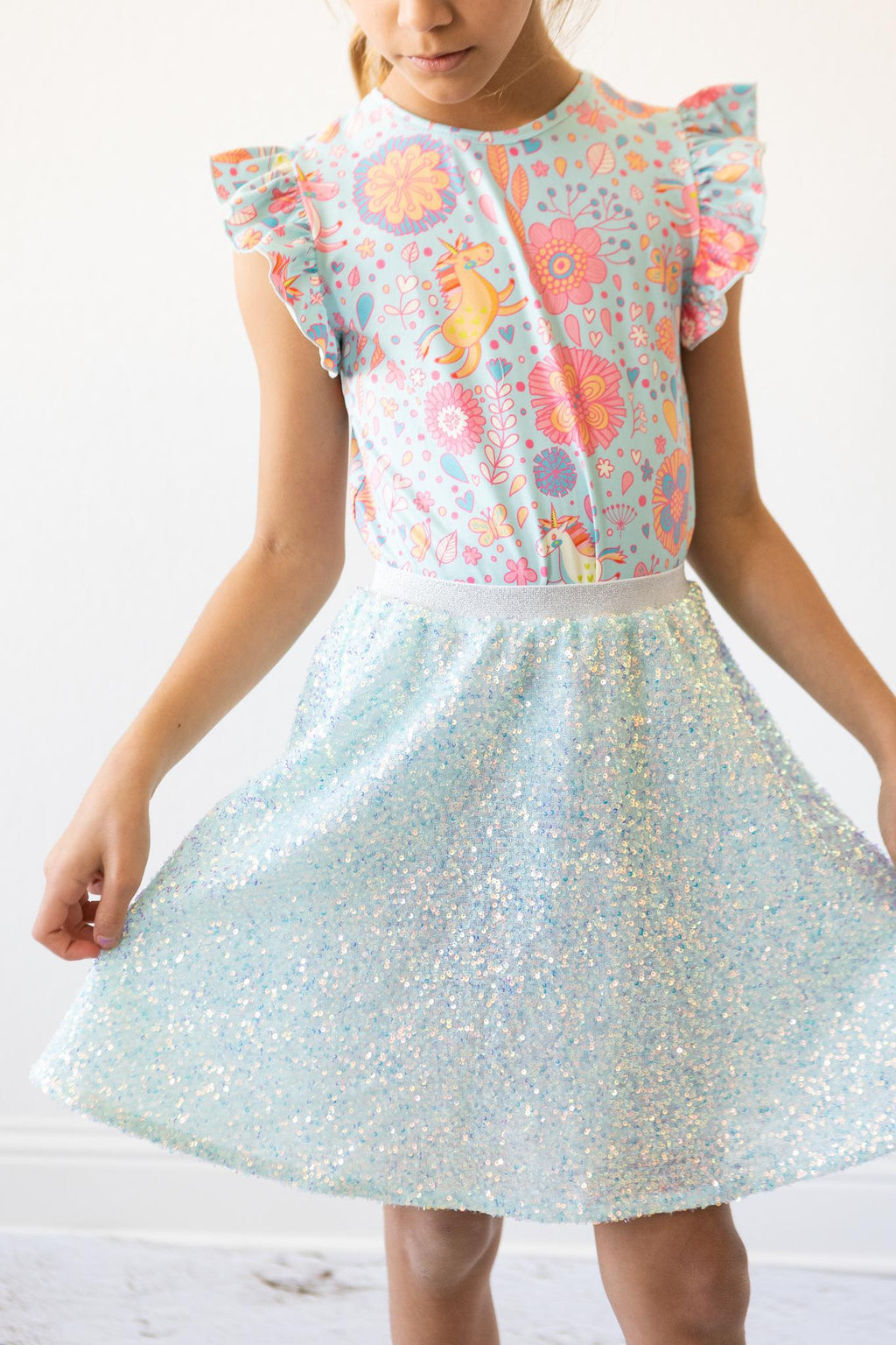Aqua Sequin Twirl Skort by Mila & Rose® on a young girl, showcasing a sparkling blue sequin design that catches the light, perfect for twirling and dancing.