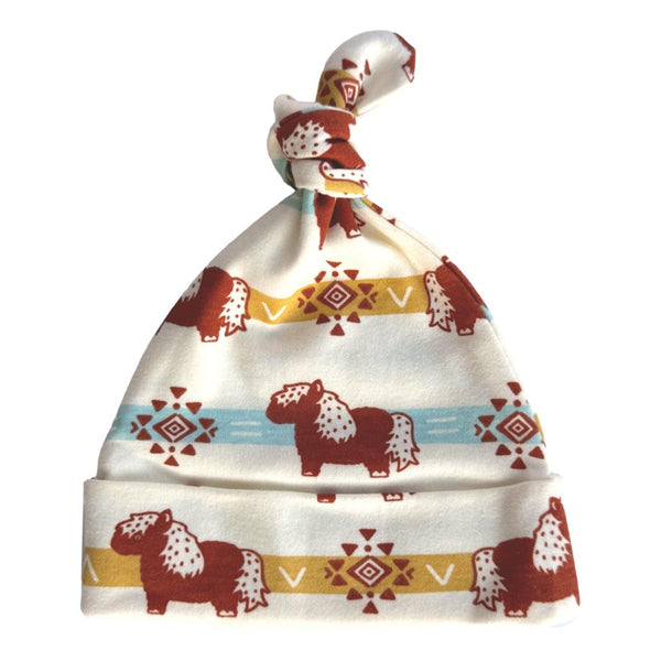 GOTS certified organic cotton knotted baby hat featuring an aztec pony pattern in earth tones with geometric accents.