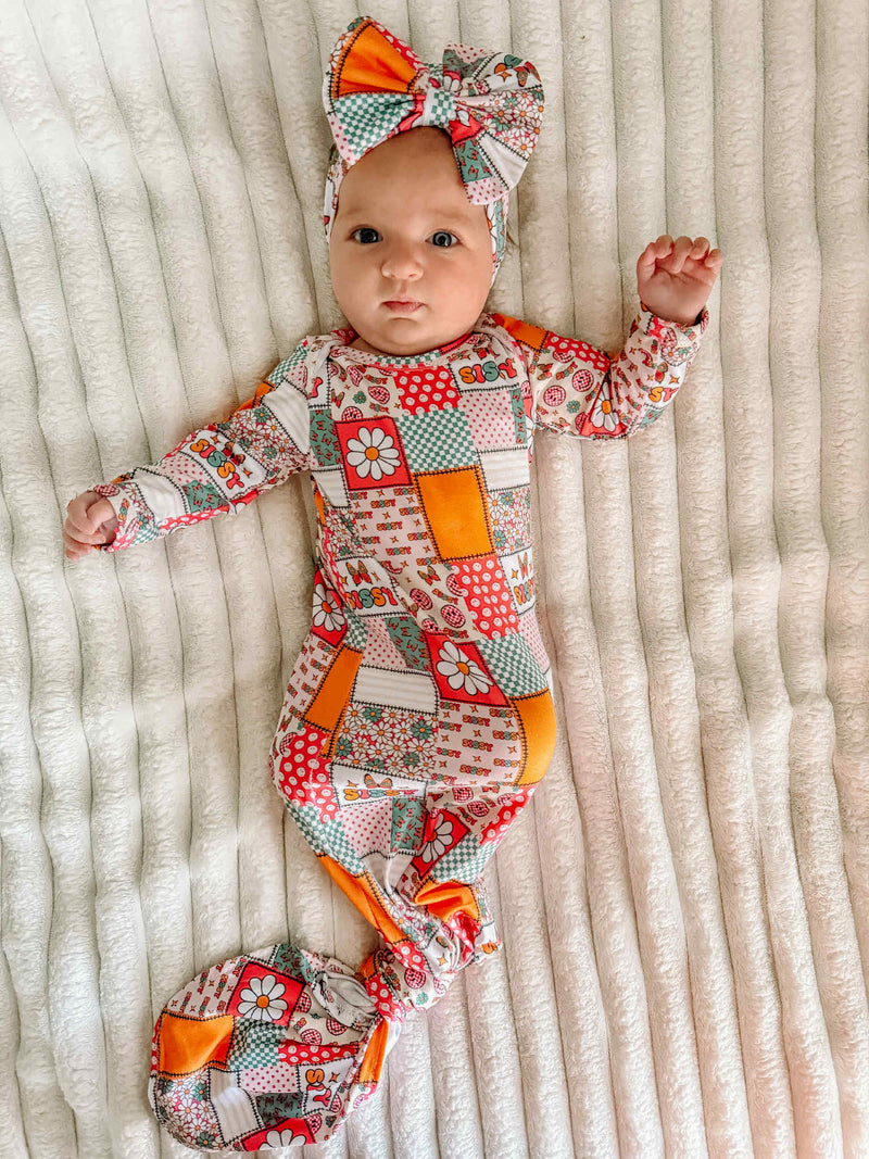 Adorable baby wearing the Anti-Kick 'Sissy' Swaddle Gown & Headband 2 PC Set, showcasing a colorful patchwork design. Perfect baby swaddle gown for keeping little ones cozy.
