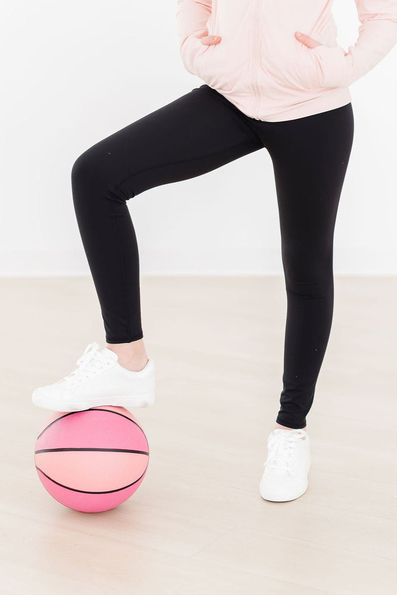 Young girl wearing Balanced Black Active Legging for Girls while dancing happily.