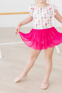 Tiny dancer in a white Ballerina Bows Short Sleeve Twirl Leotard with colorful ballerina prints and a bright pink tutu.