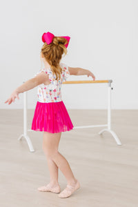 Tiny dancer wearing Ballerina Bows Short Sleeve Twirl Leotard with a bright pink tutu skirt and hair bow.