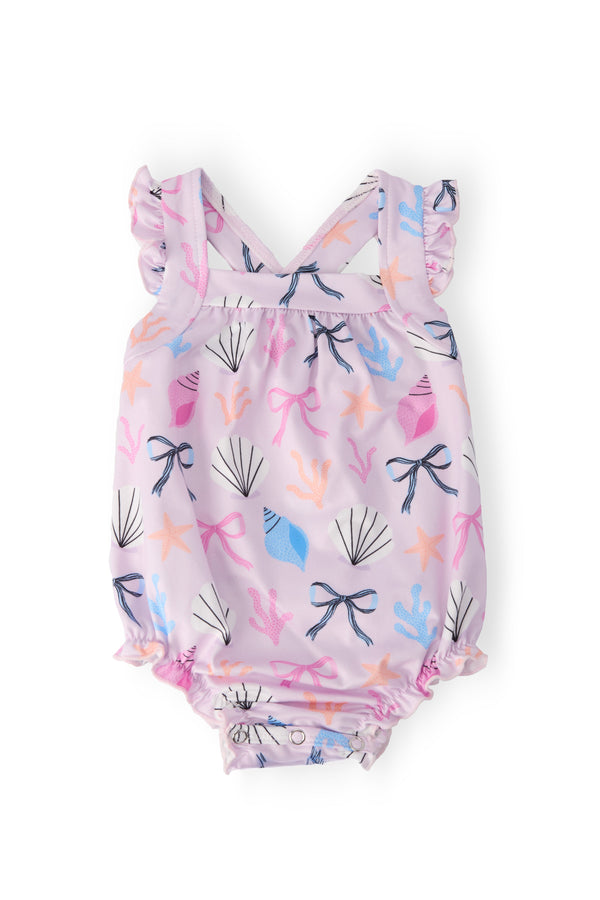 Beachside Bows Ruffle Cross Back Romper in lavender seashell and starfish print with ruffled straps and snaps