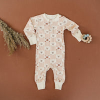 GOTS certified organic cotton playsuit featuring a pink and cream checkered bear pattern with long sleeves and snap buttons.
