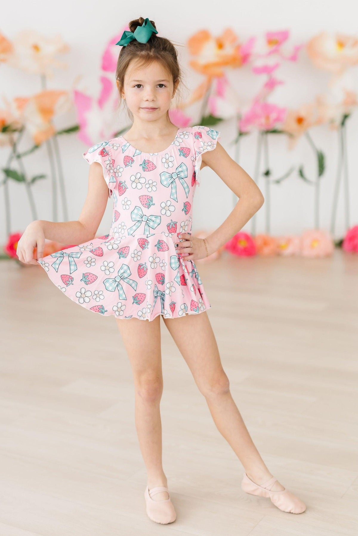 Berry Picnic Short Sleeve Twirl Leotard worn by a young dancer in pink print with strawberries, flowers, and bows.