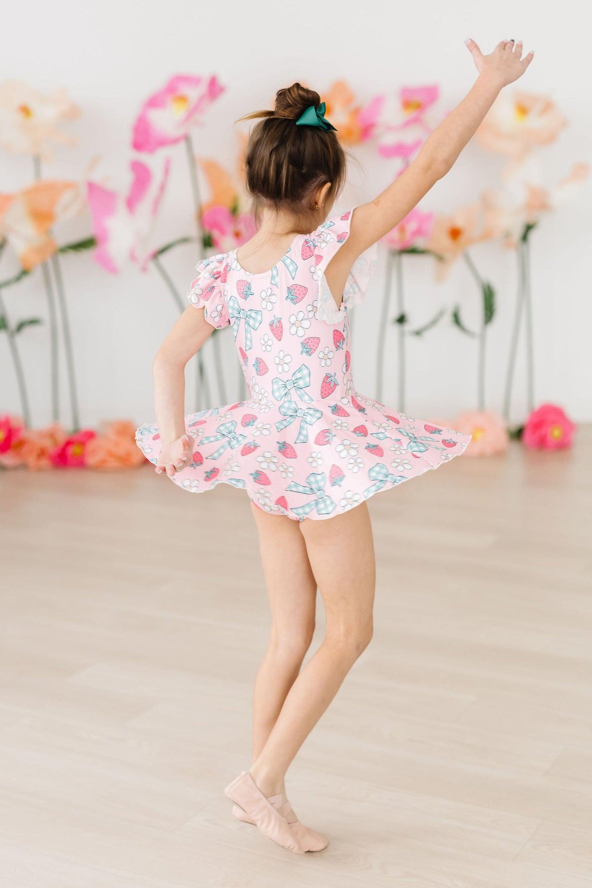 Berry Picnic Short Sleeve Twirl Leotard worn by a tiny ballerina twirling in a pink floral studio.