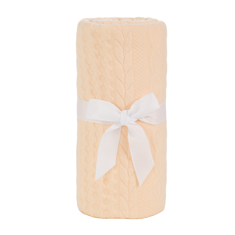 Sealy Baby Knit Blanket in Camel Sand, wrapped and secured with a white bow, highlighting its cozy design ideal for nursery decor.