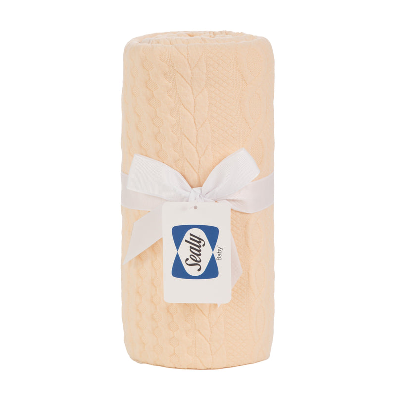 Sealy Baby Knit Blanket in Camel Sand color, elegantly rolled and tied with a white ribbon, showcasing its soft texture, perfect for newborns.