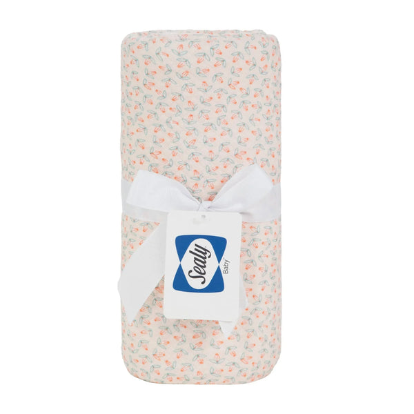  knit blanket in white with small pastel orange and green floral pattern made of soft, breathable material