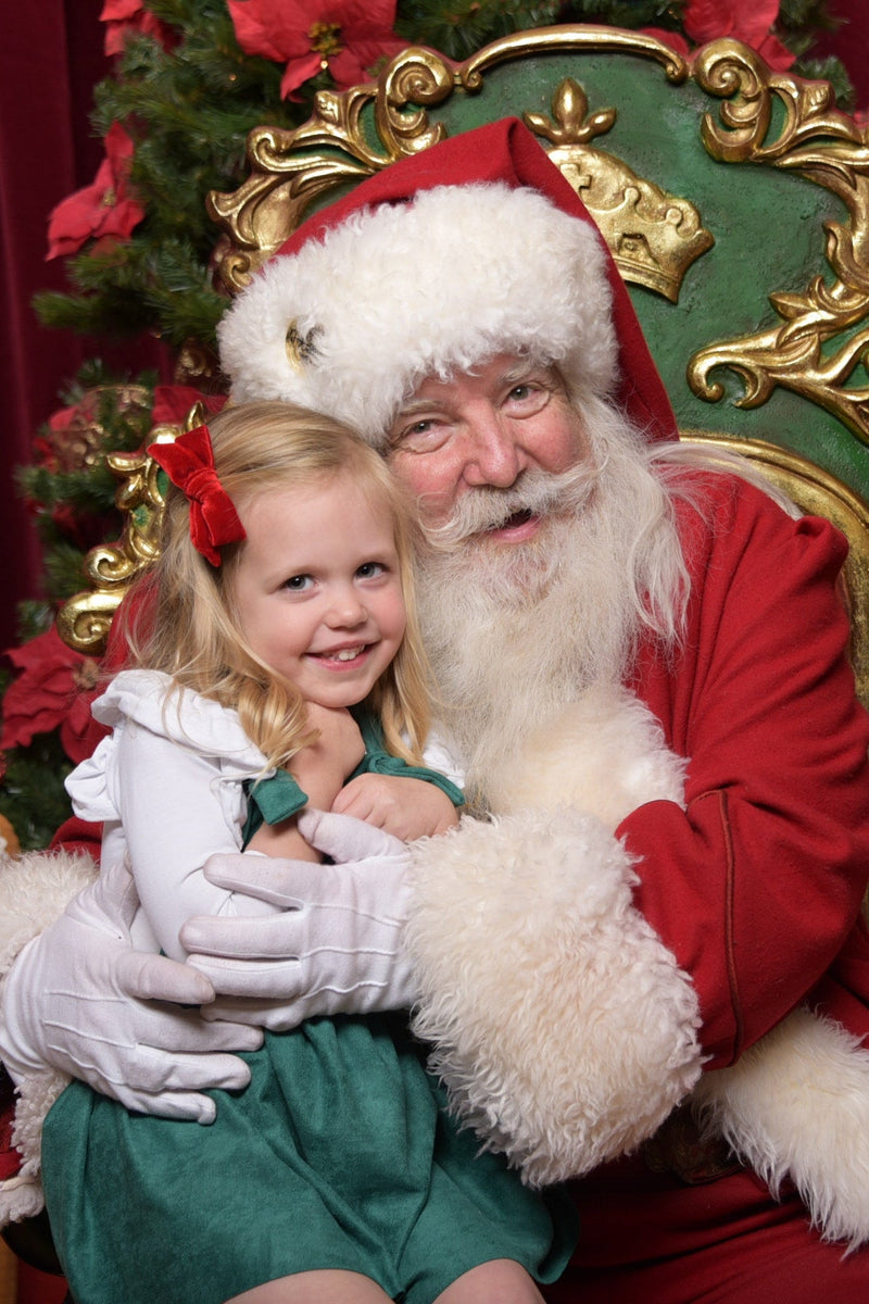 Smiling girl with Santa Claus in a festive Christmas setting.