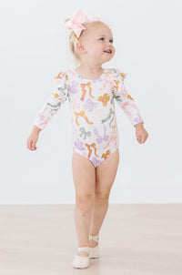 Little girl wearing the Boho Bows Long Flutter Sleeve Leotard, showcasing its elegant design and comfort, ideal flutter sleeve leotard for tiny ballerinas.