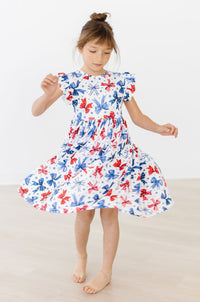 Born to Sparkle Flutter Sleeve Twirl Dress: girl twirling in white dress with red and blue butterfly print.
