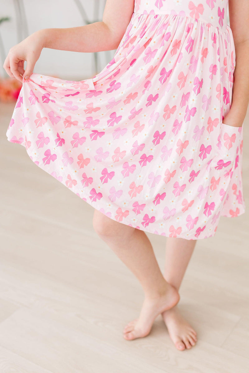 The Bow Beauty S/S Pocket Twirl Dress by Mila & Rose ® styled with Twirl Shorts, perfect for fashionable young girls who love to twirl.