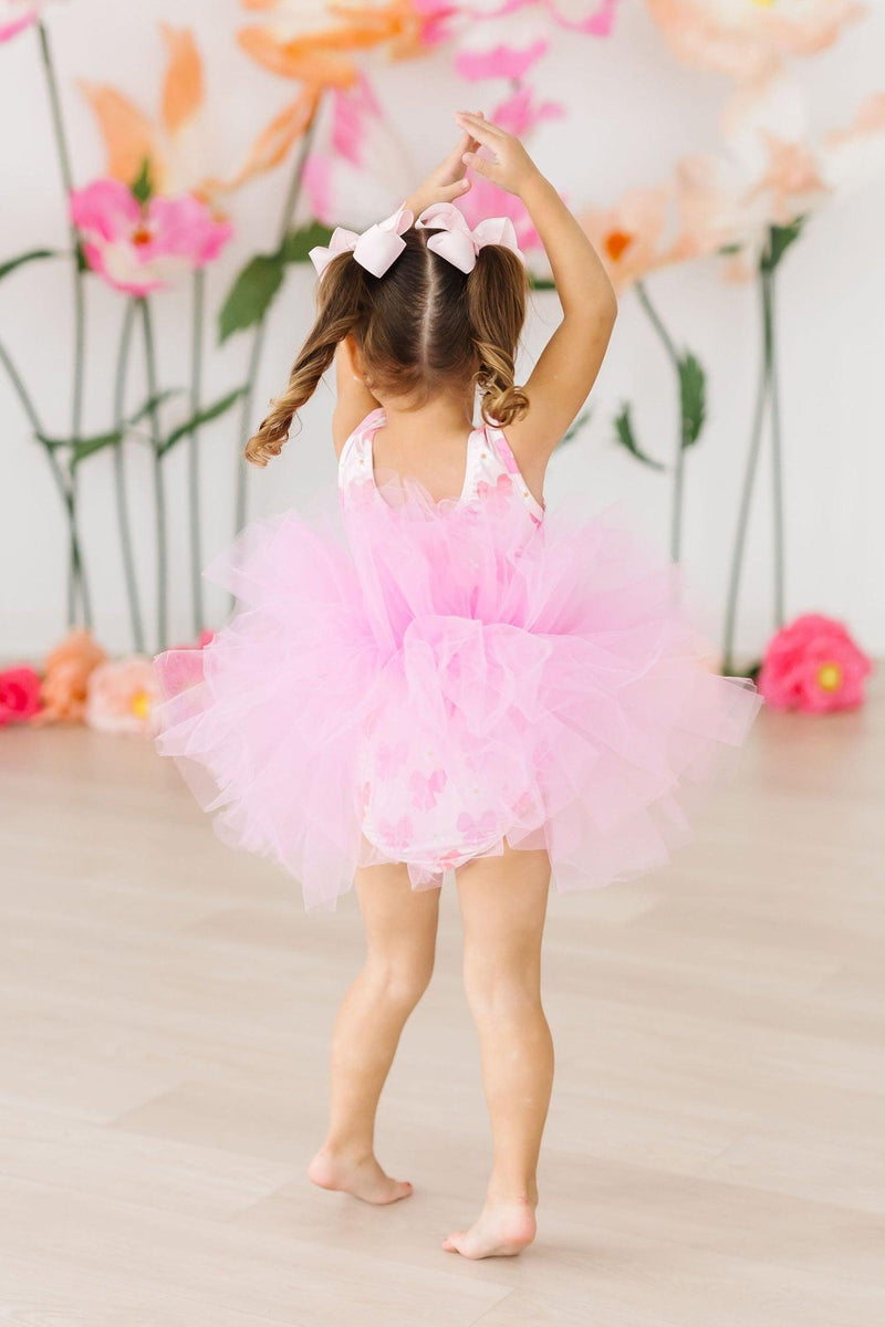 Child modeling the Bow Beauty Tank Tutu Leotard in a dance pose, illustrating comfort and style for ballet and play.