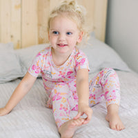 Toddler girl in The Second-Skin 2-Piece Short Sleeve Pajama, Butterfly Smoochies, with hand-drawn butterfly print.