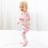Child wearing Second-Skin Convertible Romper in pink butterfly print with front zip, Raising Mama viscose fabric.