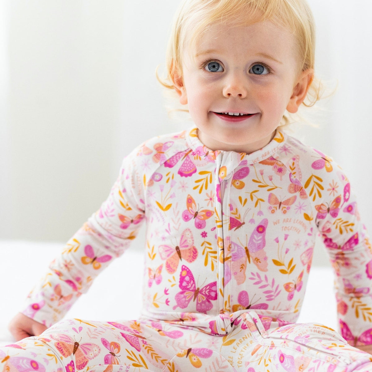 Toddler in The Second-Skin Convertible Romper by Butterfly Smoochies, pink floral butterfly print, zipper front.