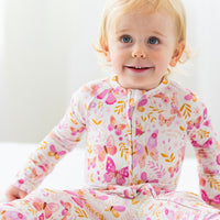 Toddler in The Second-Skin Convertible Romper by Butterfly Smoochies, pink floral butterfly print, zipper front.