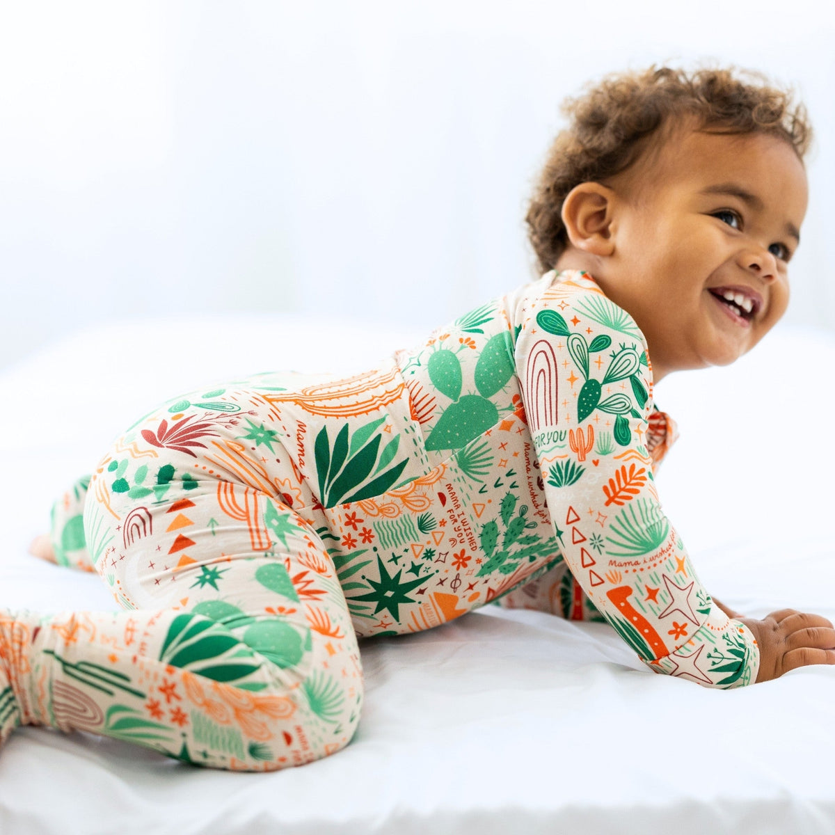 Baby in The Second-Skin Convertible Romper Desert Cactus Beige with cactus print and two-way zip.