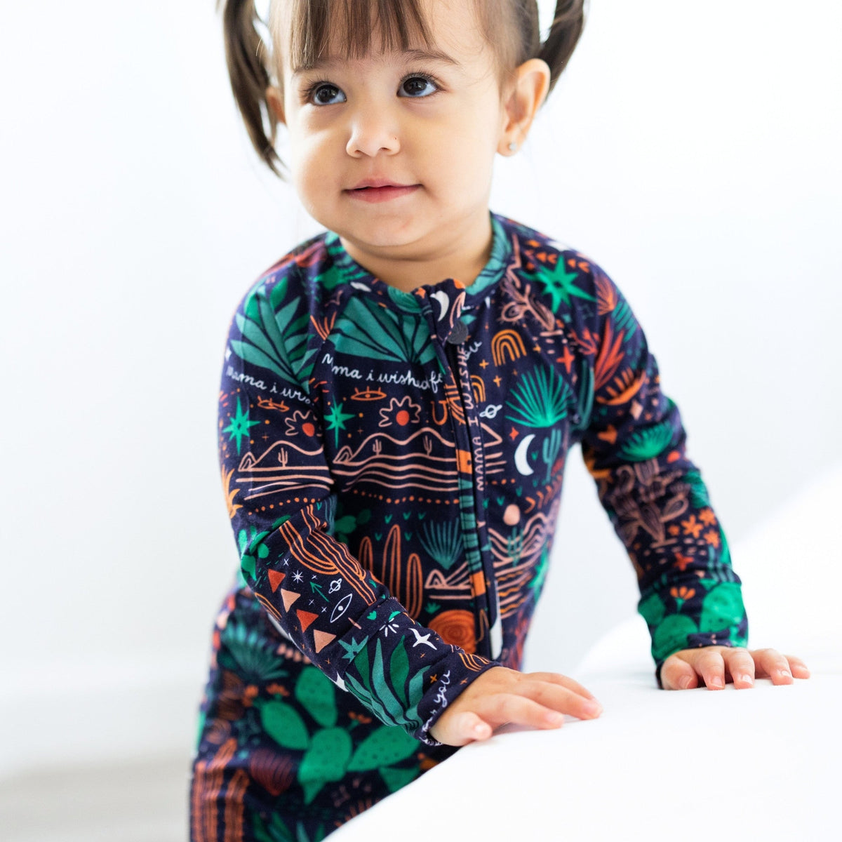 Child wearing Desert Cactus Midnight second-skin convertible romper with front zipper and bold tropical desert print.