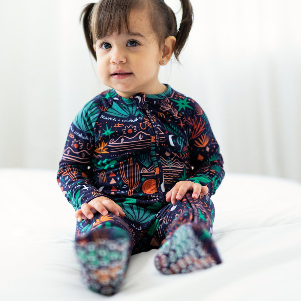 Child in zippered The Second-Skin Convertible Romper, Desert Cactus (Midnight) print.