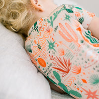 Beige Desert Cactus 2-piece short-sleeve pajama worn by a person, close-up print detail.