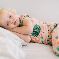 Sleeping child in beige Desert Cactus two-piece short-sleeve pajama set.