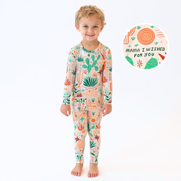 Child wearing Desert Cactus beige 2-piece long-sleeve pajama featuring cactus print and Mama I Wished For You text.