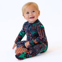 Baby wearing The Second-Skin Footie Desert Cactus Midnight, a zippered one-piece pajama.