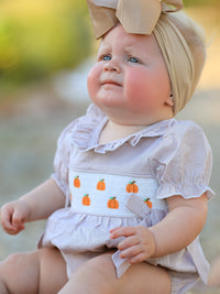 Fall Halloween & Thanksgiving pumpkin-embroidered plaid smock romper for baby girl with beige headwrap.
