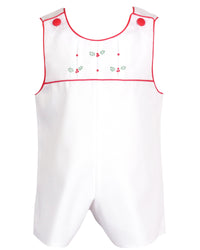 White cotton pique baby romper with pleated yoke, red trim, and embroidered holly berries for holiday wear.