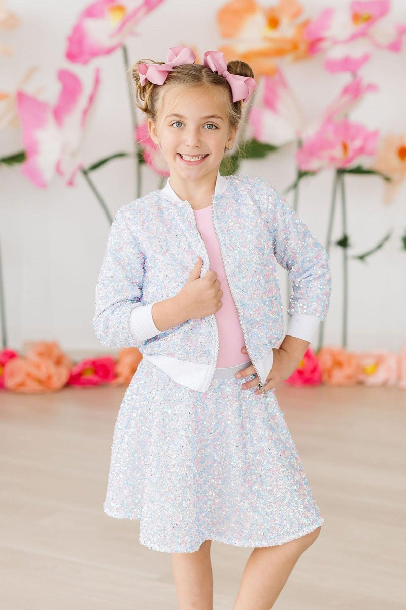 Cotton Candy Sequin Jacket for Girls - Zippered Front paired with a matching Twirl Skort, modeled by a cheerful girl in a bright setting with floral decor.