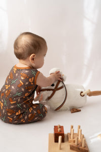 Back view of sleeveless snap closure romper showing Highland cow pattern