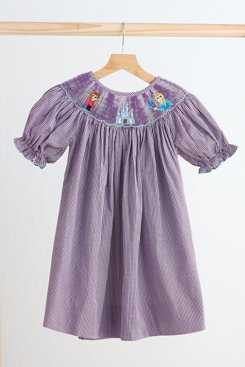 Purple checkered dress with embroidered designs on a wooden hanger against a white background