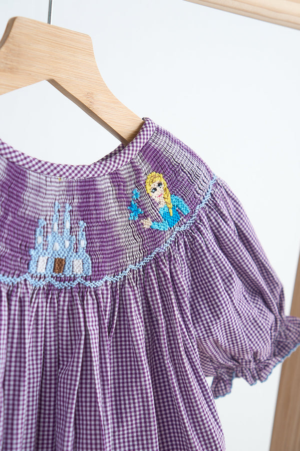 Purple checkered dress with embroidered design on a hanger