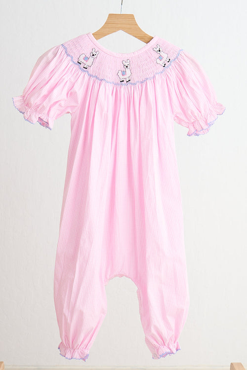 Pink gingham girl romper with hand-smocked alpaca designs on the chest and ruffled short sleeves.
