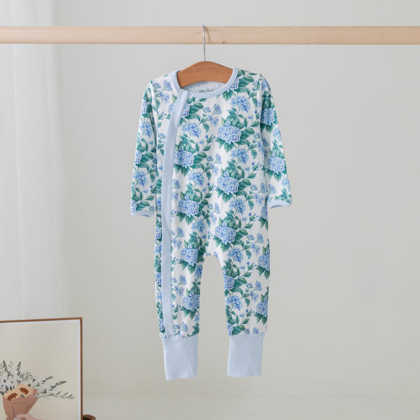 Hydrangea Heaven organic cotton kids pajama set with blue hydrangea print on a wooden hanger
