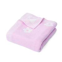 Single light purple receiving blanket folded into square on white background, corner lifted to reveal soft inner texture and