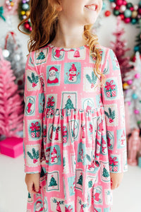 Pink long sleeve twirl dress with Santa, snowman, and gift print. Features a front pocket and full skirt for festive fun.