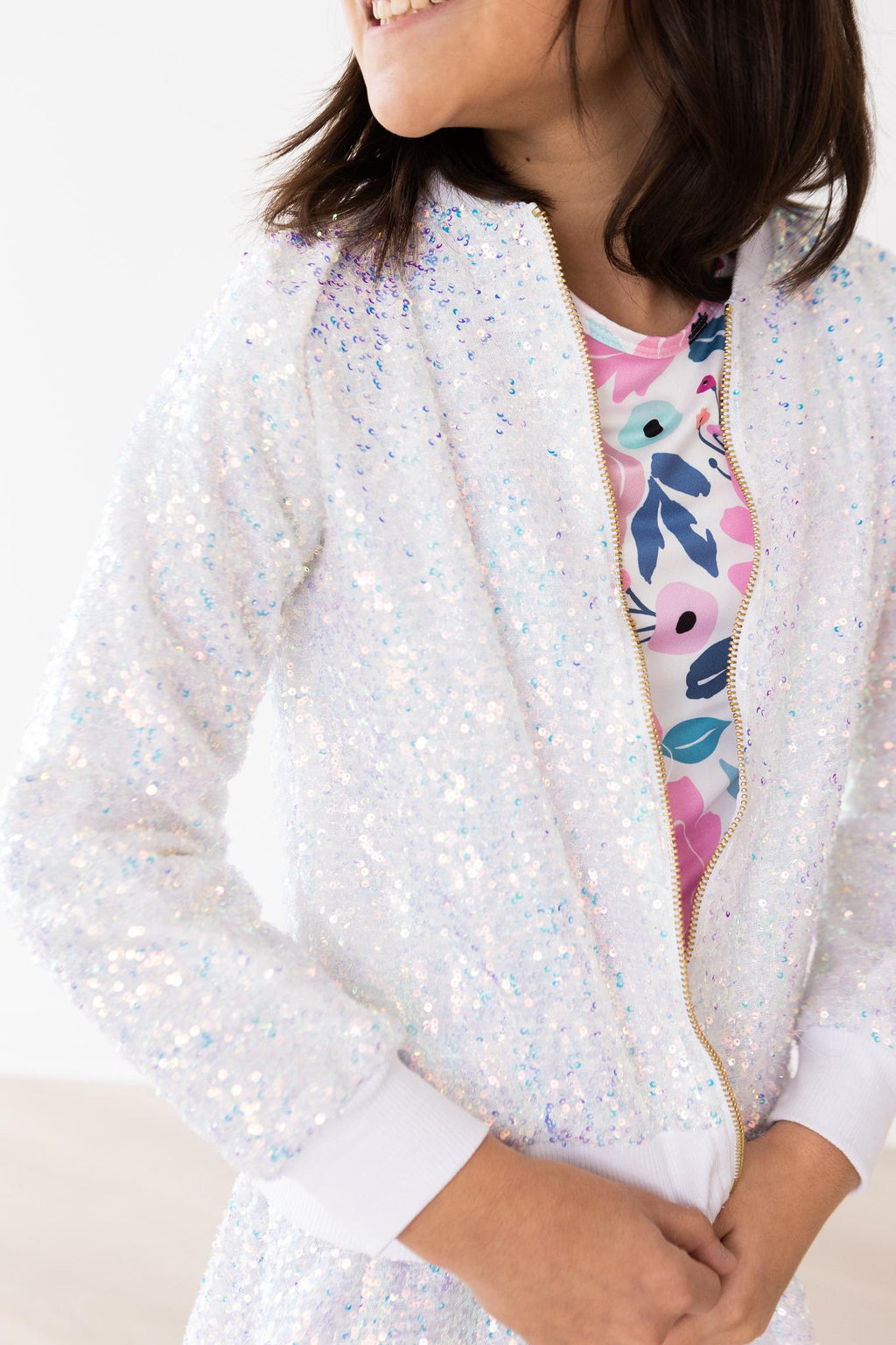Girl smiling while wearing the SALE Disco Sequin Jacket by Mila & Rose, showcasing sparkling sequins perfect for fashion-forward kids.