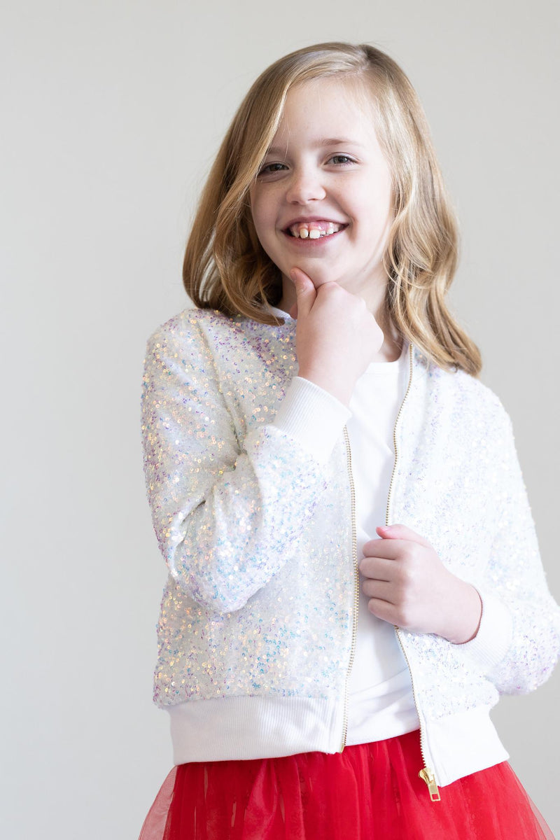 Young girl playfully posing in the SALE Disco Sequin Jacket by Mila & Rose, perfect for adding sparkle to her wardrobe.