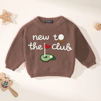 Brown ribbed-knit crewneck sweater with white 'new to the club' text and golf graphics styled with wooden bear rattle prop