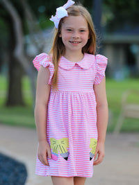 A little girl twirling in a Ruffle Bow Pencil Twirl Dress, exemplifying the fun of back to school dresses.
