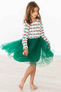 Girl twirling in a long sleeve "Fa La La" print dress with a festive green tutu skirt for holiday play.
