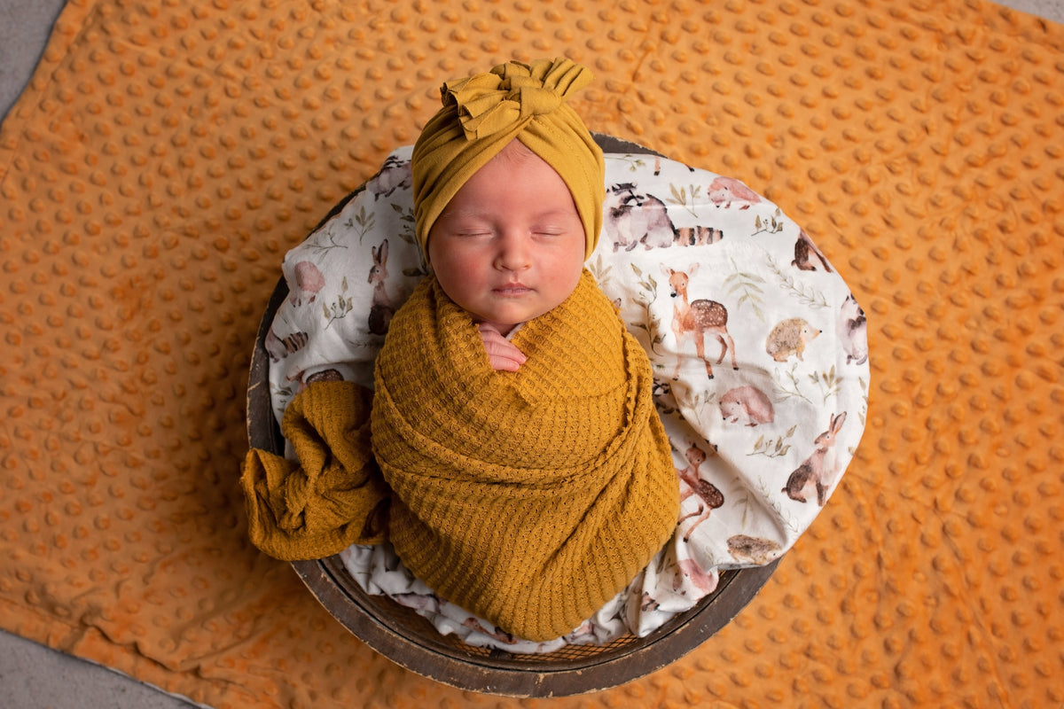 Orange minky dot blanket with woodland animal print lining, shown soft and durable for baby use.